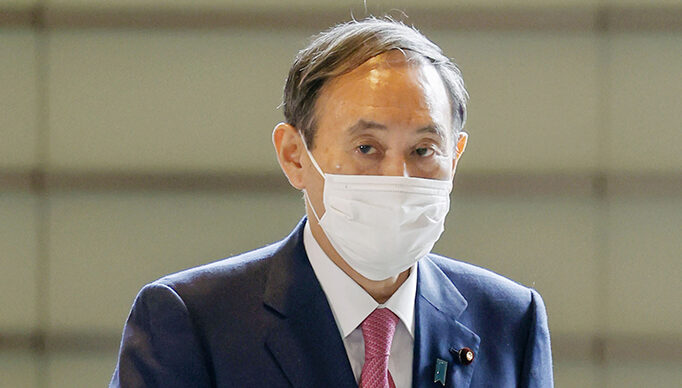 Japanese Prime Minister Yoshihide Suga arrives at his office in Tokyo on Oct. 16, 2020, wearing a mask amid continued worries about the novel coronavirus. (Photo by Kyodo News via Getty Images)